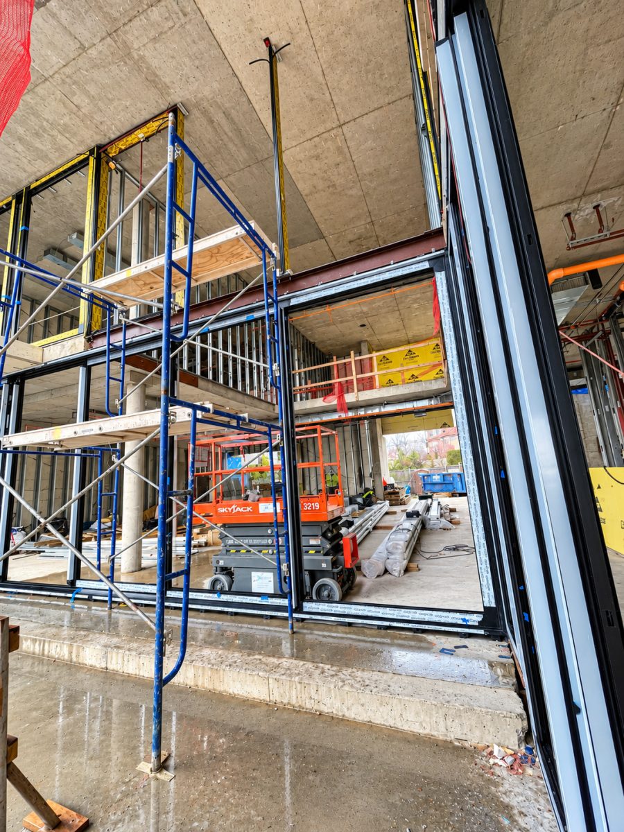 Large Schüco sliding door frame installed in a double-height opening