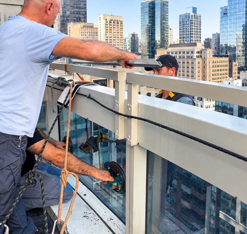 Glazing crew setting a replacement IGU from the Sofitel Hotel terrace in Manhattan
